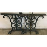 A pair of green painted cast iron scroll and floral design garden table ends.