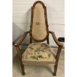 A vintage cane high backed bedroom chair with tapestry upholstery and spade front feet.
