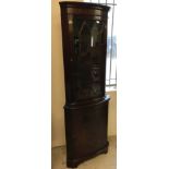 A vintage dark wood bow fronted corner unit with glazed top.