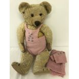 A c1930's blond haired Chad Valley jointed Teddy Bear with knitted outfit.