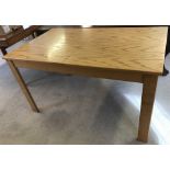 A modern light wood drawer leaf dining table with central leaf.