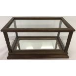 A wooden and glass display case with mirrored bottom.