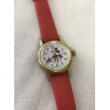 A child's Mickey Mouse wristwatch with goldtone case and red plastic strap.