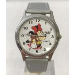 A Minnie mouse holding teddy bear wrist watch by Swatch.