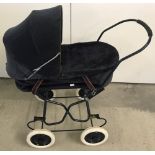 A vintage toy dolls pram with blue corduroy material.