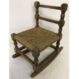 A c1960's child's/doll's rocking chair with woven rush seat.