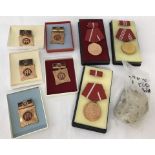 A collection of 8 assorted boxed East German medals together with a piece of the Berlin Wall.