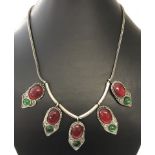 A white metal ethnic style necklace with red and green glass cabochons.