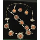 A white metal and amber brown agate jewellery set with filigree detail.