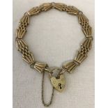 A 9ct gold gate bracelet with padlock clasp and safety chain.