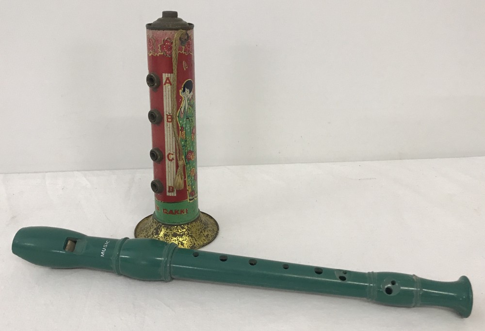 A vintage Heiwa Gakki tin whistle together with a green plastic recorder.