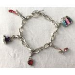 A white metal charm bracelet with t bar clasp. With 5 clip on charms.