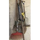 A collection of vintage garden tools to include rakes, hoes, forks and a rabbiting spade.