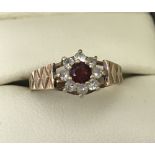 A 9ct yellow gold garnet and white stone dress ring.
