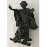 A bronze figurine of a robed oriental gentleman.