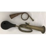 A vintage brass car horn together with a copper and brass hunting horn.