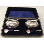 A boxed set of silver salts and salt and matching spoons.