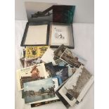 A quantity of vintage loose postcards together with a postcard album.