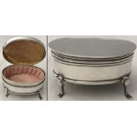 A oval shaped silver trinket box on 4 small cabriole style feet. Inside lined with pink satin.