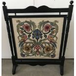 A vintage wooden framed tapestry fire screen with iris and bird decoration.