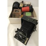 A box of assorted vintage photography equipment and accessories.