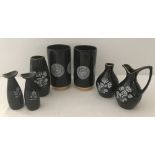 A small collection of black, white and gilt wade ceramic vases and a jug.