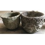 2 circular shaped concrete garden planters with decoration to sides.