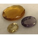 3 unset semi precious stones. Large deep coloured citrine, a pale citrine and an amethyst.