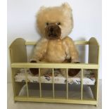 A 1950's Blonde Schuco nursery bear together with a vintage wooden toy dolls cot.