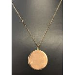 A 9ct rose gold plated (front & back) circular locket on a 9ct gold chain.
