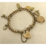 A 9ct gold charm bracelet with heart shaped padlock and 7 charms.