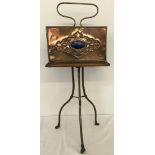 An Arts and Crafts brass and walnut revolving magazine rack.