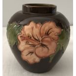 A Moorcroft small ceramic brown vase decorated with coral hibiscus flowers.