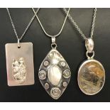 3 silver and white metal pendants on chains.