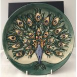 A Moorcroft 1994 limited edition peacock plate in green, blue and orange colour palette. With box.