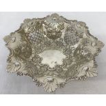 A decorative silver bon bon dish with fruit, flowers and clam shell decoration.