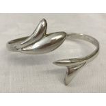 A white metal fish tail bangle with Arabic Hallmarks.