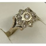 A 9ct gold and diamond illusion set dress ring in flower design.