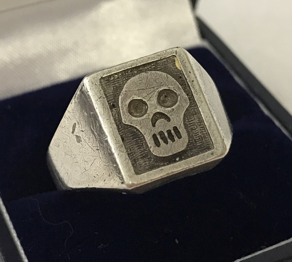 A men's silver ring with skull decoration to top.