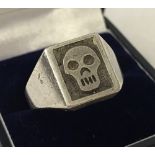 A men's silver ring with skull decoration to top.