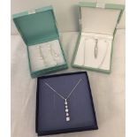 2 boxed silver necklaces together with a boxed pair of earrings.