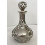 A silver and clear glass perfume bottle.