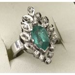 Unusual 18ct white gold dress ring set with a pear cut emerald and 11 small diamonds.
