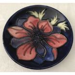 A Moorcroft blue ceramic pin dish with anemone decoration.