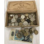 A box containing a collection of vintage coins, mostly foreign.