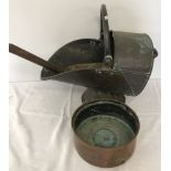 A vintage brass coal scuttle together with a copper planter and a metal shovel.