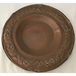 An Arts & Crafts circular copper shallow dish with decorated rim and scalloped edge.