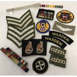A collection of military cloth badges and ribbon bars.
