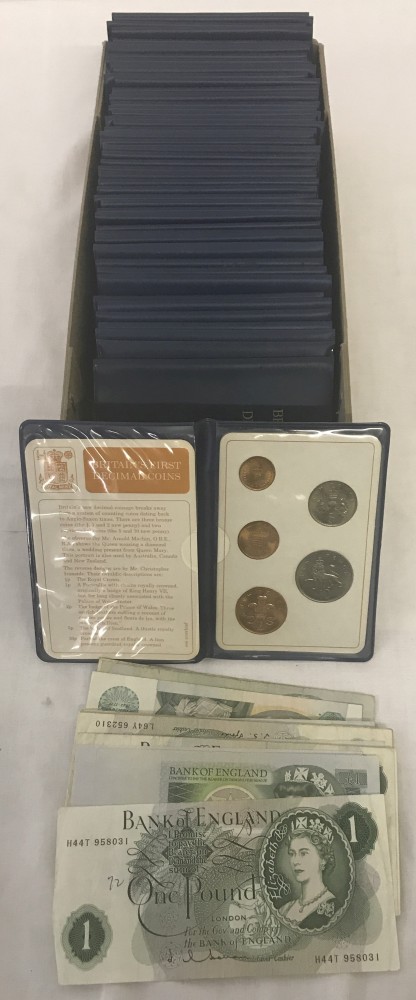 A box containing 50 British Decimal coinage sets together with 26 £1 notes.