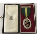 A boxed Territorial Decoration medal with Canada clasp and green and yellow ribbon.